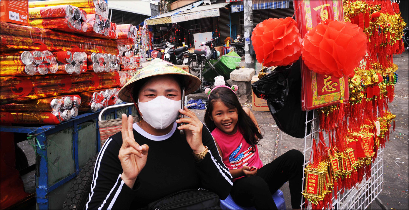 Hai mẹ con người bán đồ Tết vui mừng với một mùa xuân thắng lợi.