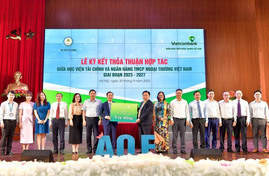 Ths Lê Hoàng Tùng - Phó Tổng Giám đốc Vietcombank (thứ 7 từ trái sang) trao biển biểu trưng cho NGND. PGS.TS. Nguyễn Trọng Cơ - Thường vụ Đảng ủy Bộ Tài chính, Bí thư Đảng ủy, Giám đốc Học viện Tài chính (thứ 8 từ phải sang) số tiền 1 tỷ đồng học bổng cho sinh viên xuất sắc giai đoạn 2023 - 2027