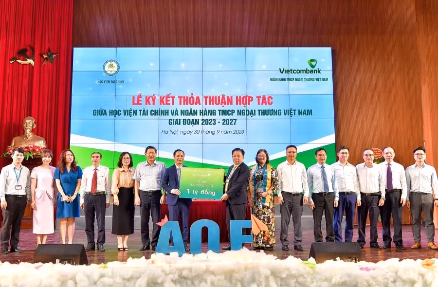 Ths Lê Hoàng Tùng - Phó Tổng Giám đốc Vietcombank (thứ 7 từ trái sang) trao biển biểu trưng cho NGND. PGS.TS. Nguyễn Trọng Cơ - Thường vụ Đảng ủy Bộ Tài chính, Bí thư Đảng ủy, Giám đốc Học viện Tài chính (thứ 8 từ phải sang) số tiền 1 tỷ đồng học bổng cho sinh viên xuất sắc giai đoạn 2023 - 2027