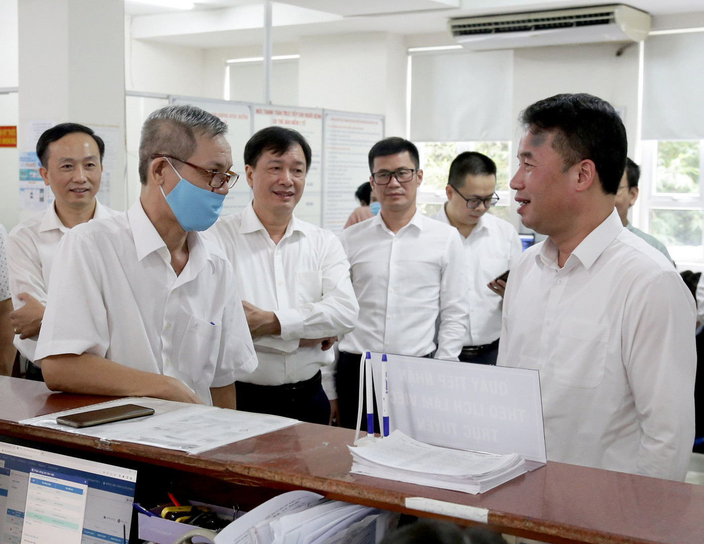 Ông Nguyễn Thế Mạnh (phải), Tổng Giám đốc BHXH Việt Nam kiểm tra công tác thí điểm ứng dụng sinh trắc học trong giải quyết thủ tục hành chính.