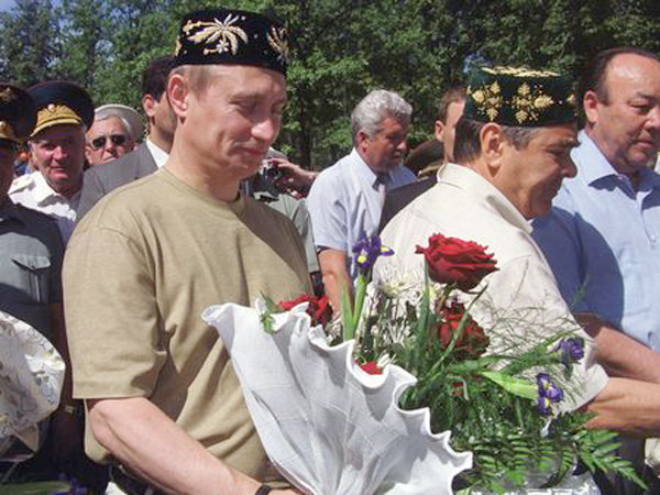 Putin ôm hoa và đội chiếc mũ Tatar truyền thống trong chuyến thăm Cộng hoà Tatarstan thuộc Nga năm 2000.