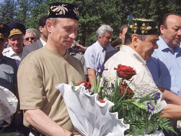 Putin ôm hoa và đội chiếc mũ Tatar truyền thống trong chuyến thăm Cộng hoà Tatarstan thuộc Nga năm 2000.