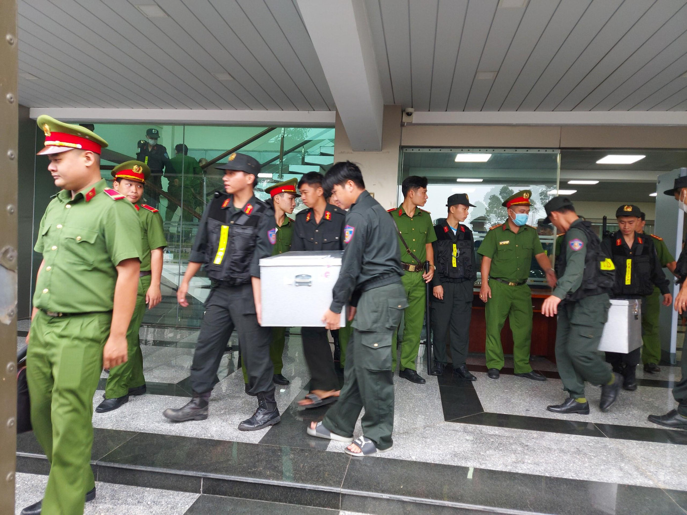 Cảnh sát mang tài liệu vụ án vào phòng xử án. Cảnh sát mang tài liệu vụ án vào phòng xử án.