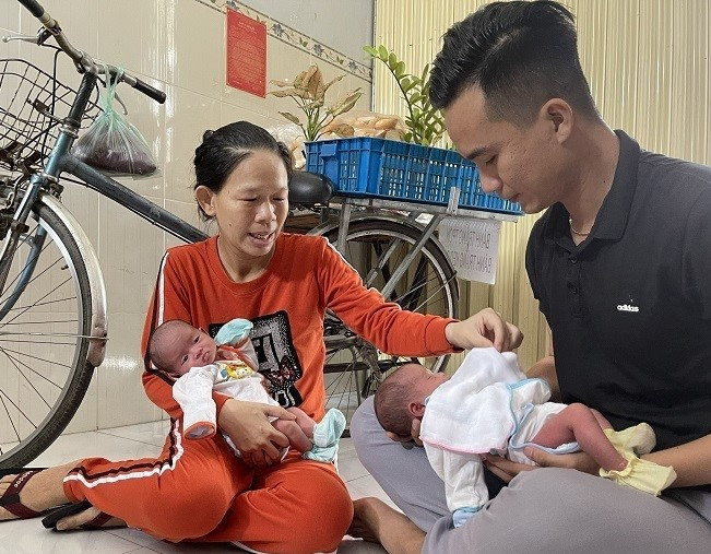 Chị Dung và anh Trung bế hai bé song sinh.
