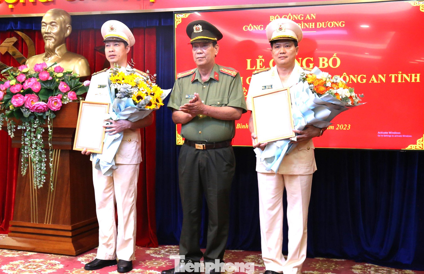 Đại tá Nguyễn Văn Dựt, Phó giám đốc Công an tỉnh Bình Dương trao quyết định cho thượng tá Lưu Minh Hoàng (bìa trái) và thượng tá Đặng Đình Hà (bìa phải)