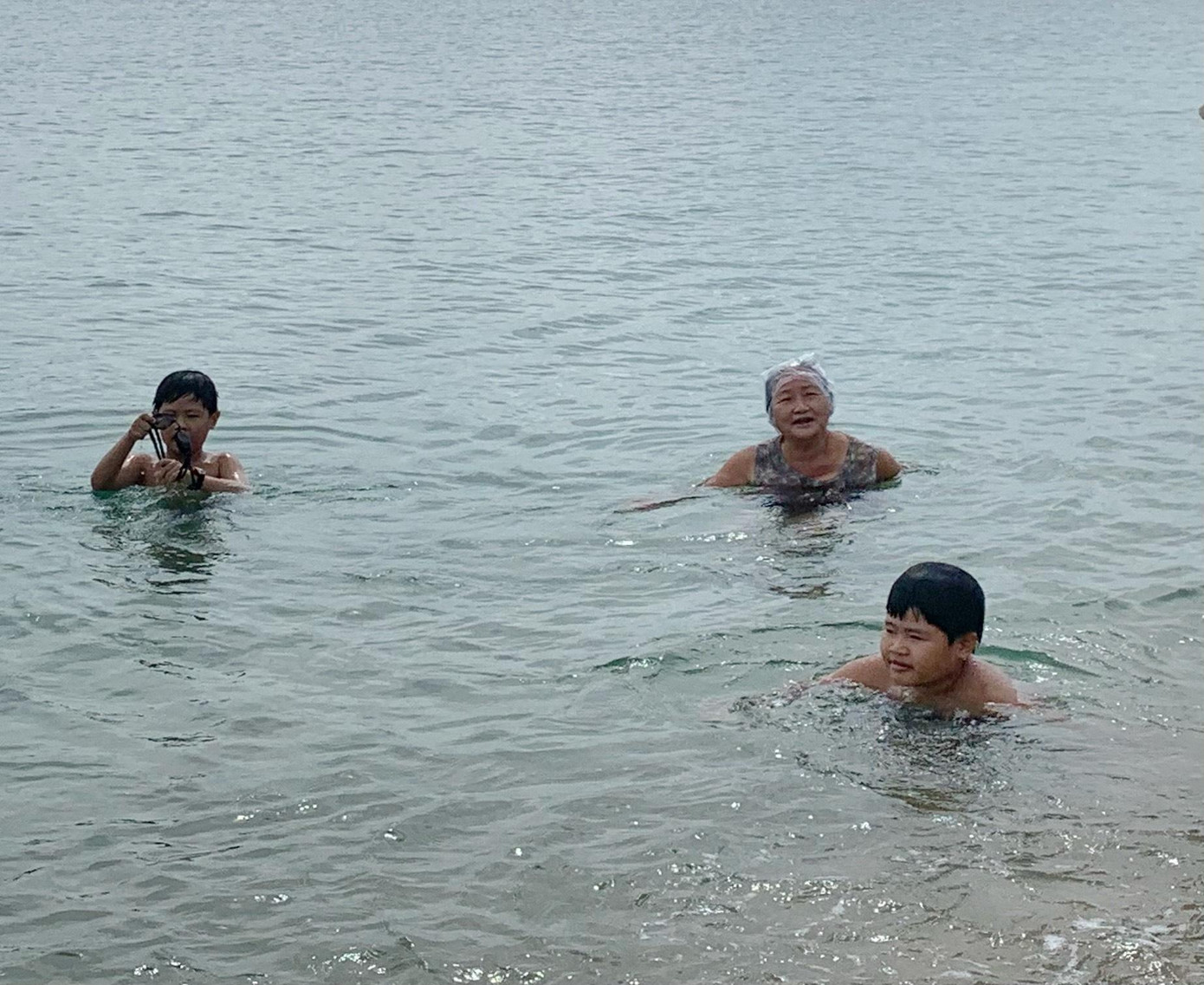 Nhiều trẻ em cũng vui sướng đi theo người lớn tắm biển Nhiều trẻ em cũng vui sướng đi theo người lớn tắm biển