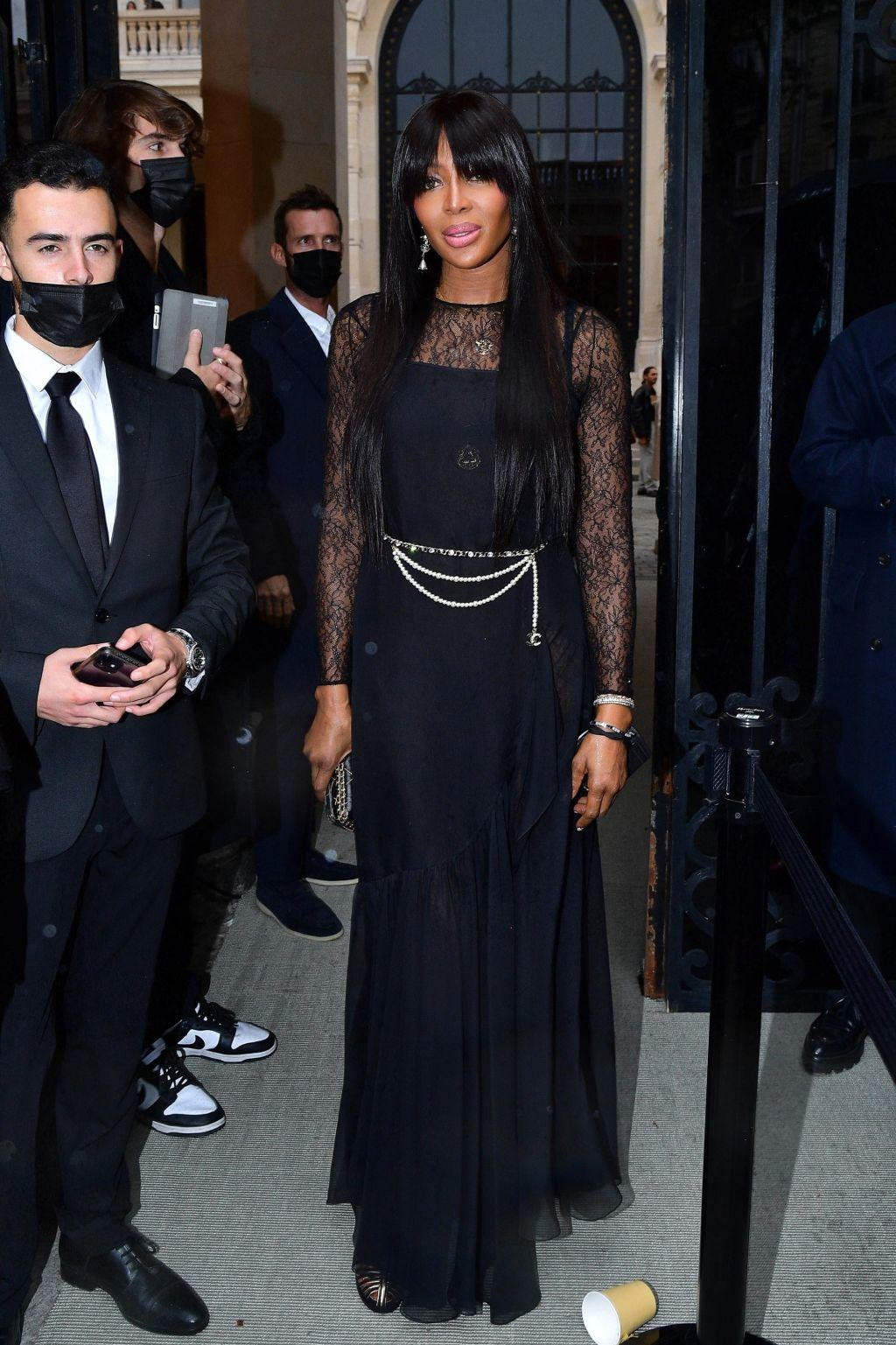 "Báo đen" Naomi Campbell kín đáo với đầm đen tay ren. Điểm nhấn là thắt lưng dây xích bạc Chanel. "Báo đen" Naomi Campbell kín đáo với đầm đen tay ren. Điểm nhấn là thắt lưng dây xích bạc Chanel.