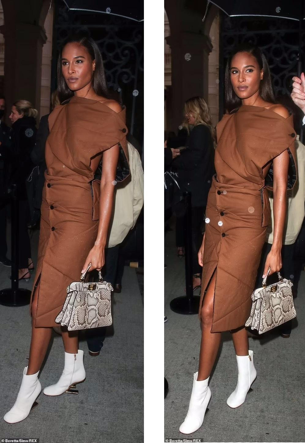 Trong khi váy nâu khá chìm, Cindy Bruna biết cách tạo điểm nhấn với túi xách họa tiết da rắn và boot trắng thấp cổ. Trong khi váy nâu khá chìm, Cindy Bruna biết cách tạo điểm nhấn với túi xách họa tiết da rắn và boot trắng thấp cổ.