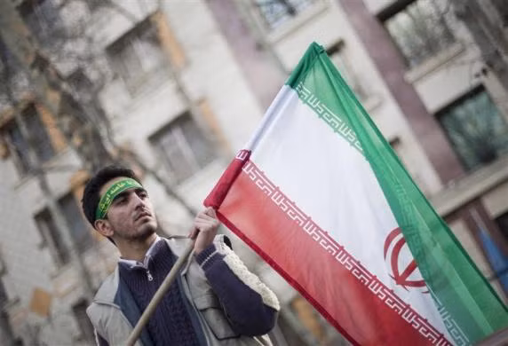 Nam sinh viên này đang cầm trên tay lá cờ nước Iran để biểu tình trước văn phòng Liên Hợp Quốc tại Tehran vào ngày 27-2-2011.