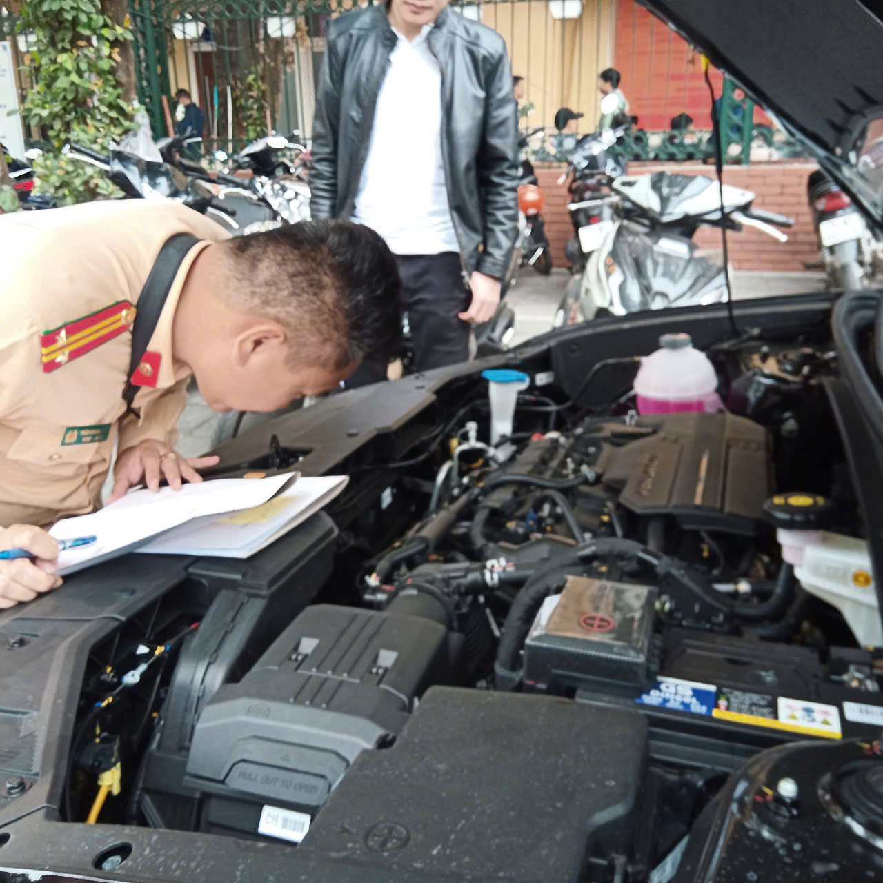 Cán bộ CSGT tất bật làm thủ tục (ảnh trái), bên cạnh đó là cảnh "nhộn nhịp" dịch vụ lắp biển. Cán bộ CSGT tất bật làm thủ tục (ảnh trái), bên cạnh đó là cảnh "nhộn nhịp" dịch vụ lắp biển.