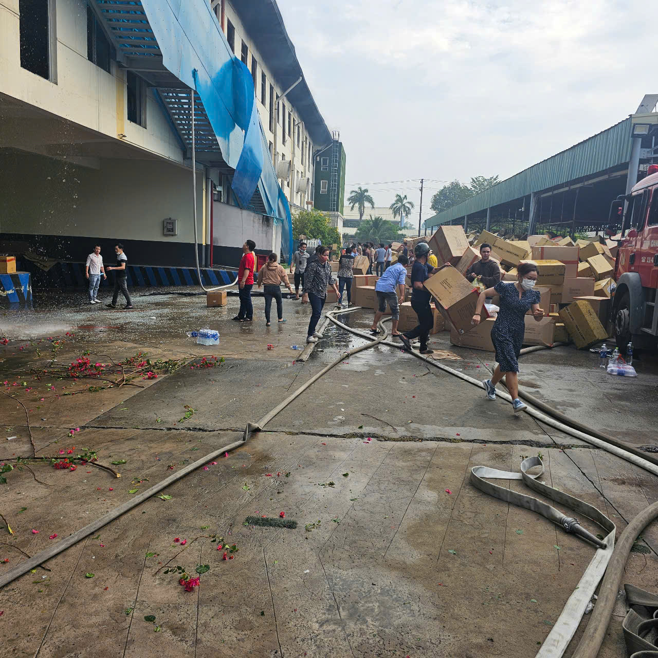 Hàng hoá được công nhân di dời ra để tránh cháy lan.