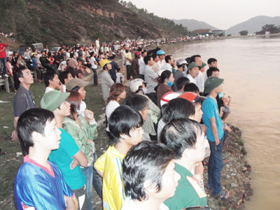 Rất đông người dân Nghệ An, Hà Tĩnh đứng bên bờ sông theo dõi việc tìm kiếm chiếc xe xấu số. Ảnh: Quang Long. Rất đông người dân Nghệ An, Hà Tĩnh đứng bên bờ sông theo dõi việc tìm kiếm chiếc xe xấu số. Ảnh: Quang Long