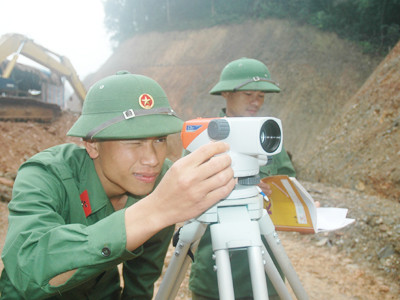 Cán bộ kỹ thuật đo đạc chỉ đạo máy đào nền Ảnh: CTV