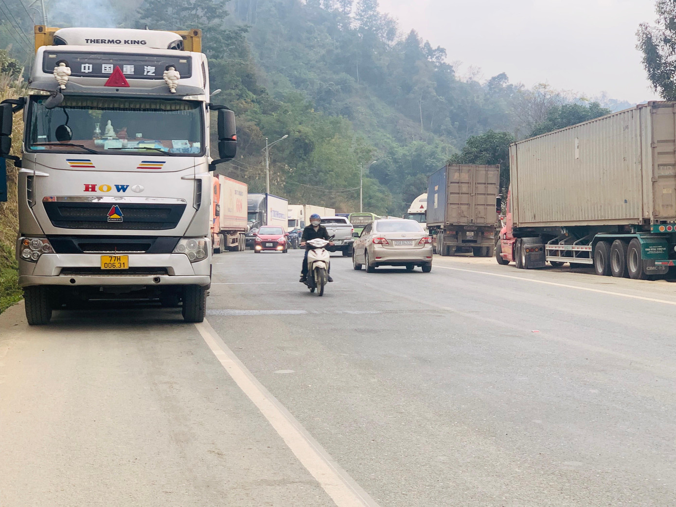 Đoàn xe ô tô chở nông sản đỗ dài trên tuyến quốc lộ 1A. Ảnh: Duy Chiến