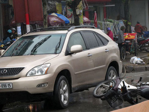 Cửa ôtô mở bất ngờ khiến xe máy tông phải, đổ ra đường. Ảnh: VnExpress