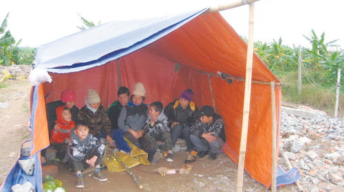 Vợ con ông Vươn ăn tết trong chiếc lều dựng tạm trên khu đất căn nhà 2 tầng đã bị phá. Ảnh: Quang Vinh. Vợ con ông Vươn ăn tết trong chiếc lều dựng tạm trên khu đất căn nhà 2 tầng đã bị phá Ảnh: Quang Vinh