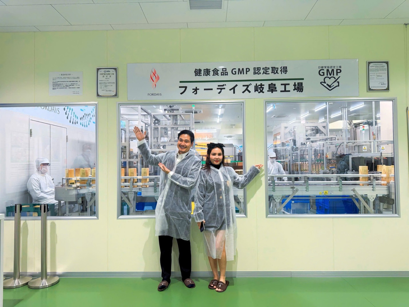 Luân Nguyễn và vợ Bảo Châu tuân thủ quy trình thanh lọc khử trùng mặc đồ bảo hộ trước khi vào tham quan nhà máy sản xuất.