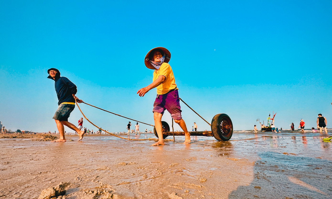 Du khách cũng có thể nhìn ngắm hay hòa cùng ngư dân đưa thuyền từ bờ xuống biển để chuẩn bị cho một ngày mới lao động trên biển.