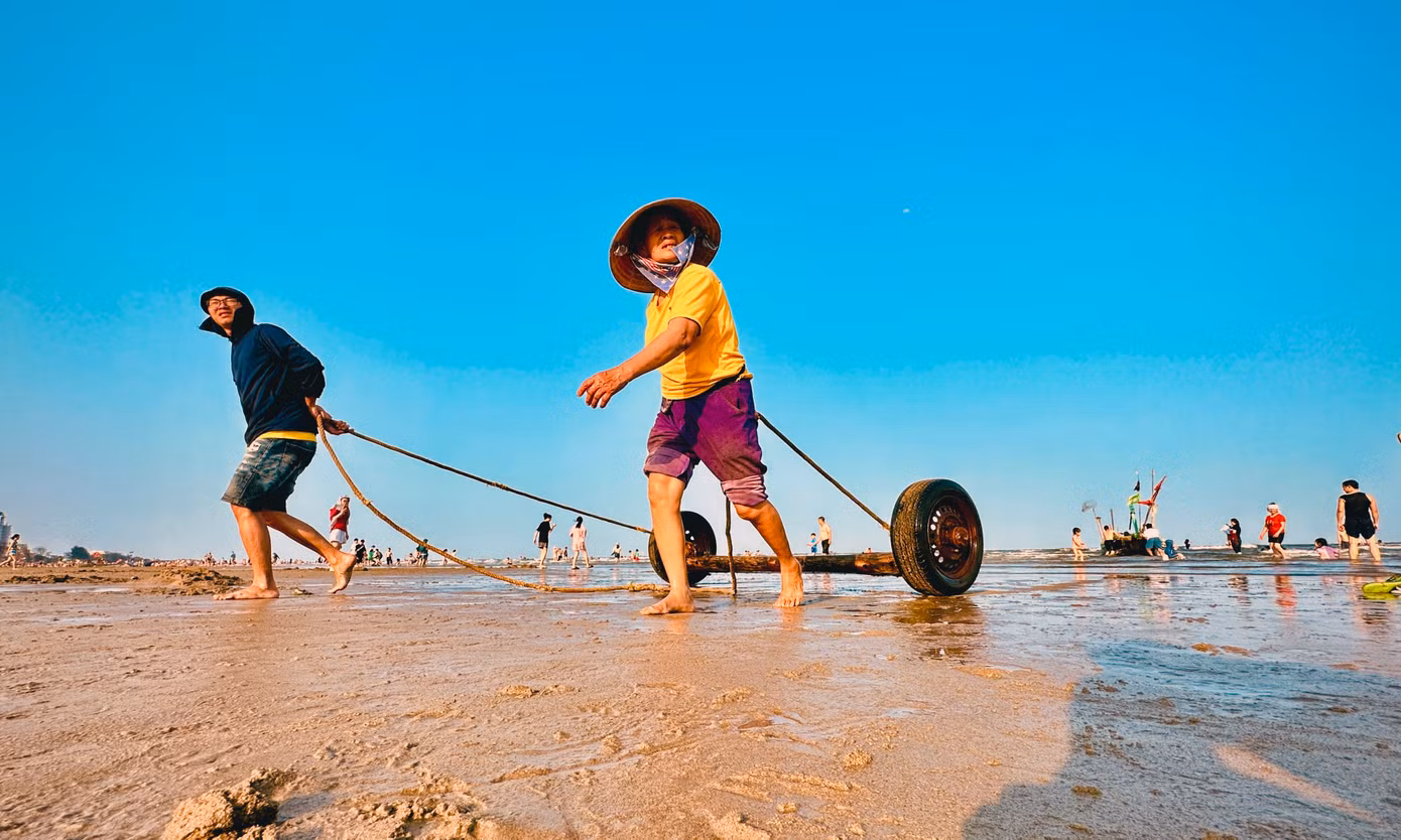 Du khách cũng có thể nhìn ngắm hay hòa cùng ngư dân đưa thuyền từ bờ xuống biển để chuẩn bị cho một ngày mới lao động trên biển.