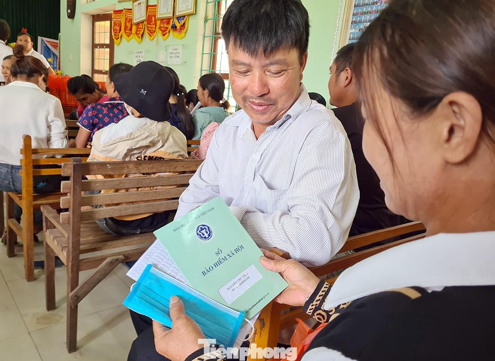 Người dân thôn Bưởi Rỏi (xã Quảng Hợp, huyện Quảng Trạch, Quảng Bình) vui mừng khi cầm trên tay cuốn sổ BHXH khi tham gia BHXH tự nguyện. Ảnh: Phạm Thanh.
