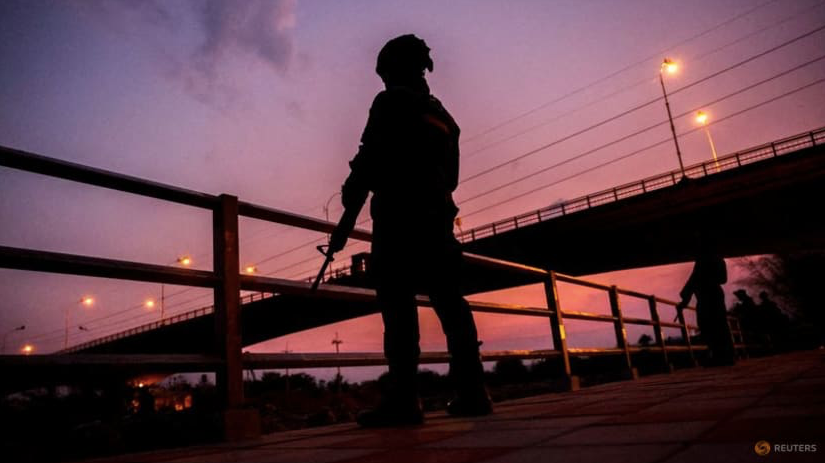 Binh lính đứng gác khi hàng trăm người băng qua sông giữa Myanmar và Thái Lan ở Mae Sot ngày 13/4. (Ảnh: Reuters) Binh lính đứng gác khi hàng trăm người băng qua sông giữa Myanmar và Thái Lan ở Mae Sot ngày 13/4. (Ảnh: Reuters)