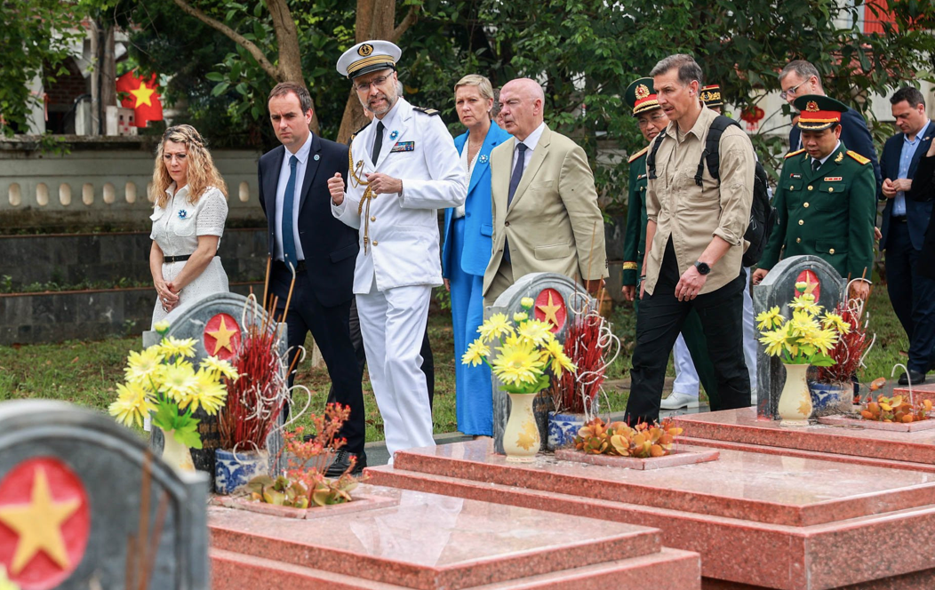 Đoàn quan chức và cựu binh Pháp được nghe giới thiệu về nơi yên nghỉ của các anh hùng và chiến sĩ hy sinh trong trận chiến Điện Biên Phủ. (Ảnh: VietnamNet)