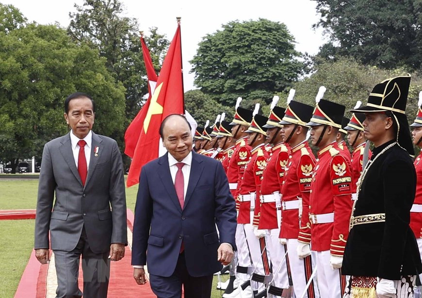 Chủ tịch nước Nguyễn Xuân Phúc và Tổng thống nước Cộng hòa Indonesia Joko Widodo duyệt đội danh dự. (Ảnh: Thống Nhất/TTXVN)