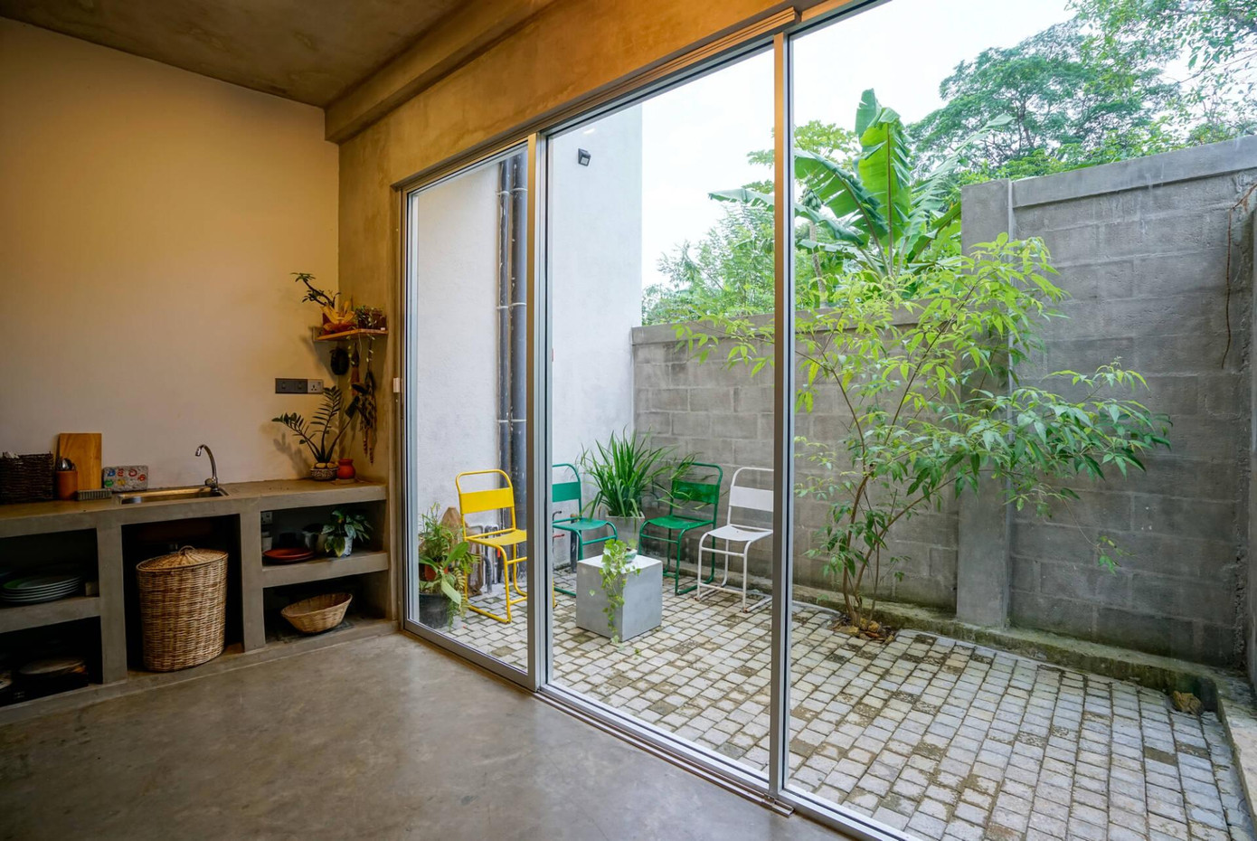 Tầng 1 của khu vực chức năng bao gồm bếp, phòng ngủ và nhà vệ sinh. Nơi chế biến thức ăn được thiết kế đơn giản, trong đó toàn bộ phần sàn, tường và mái nhà được để thô không sơn hay trang trí.Đặc biệt, gian bếp mở thông với một sân nhỏ để lấy sáng.