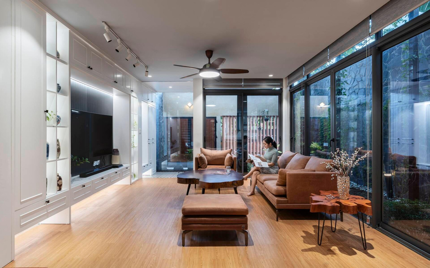 Nhờ các tấm cửa kính cỡ lớn mà phòng khách luôn tràn ngập ánh sáng từ sân vườn.