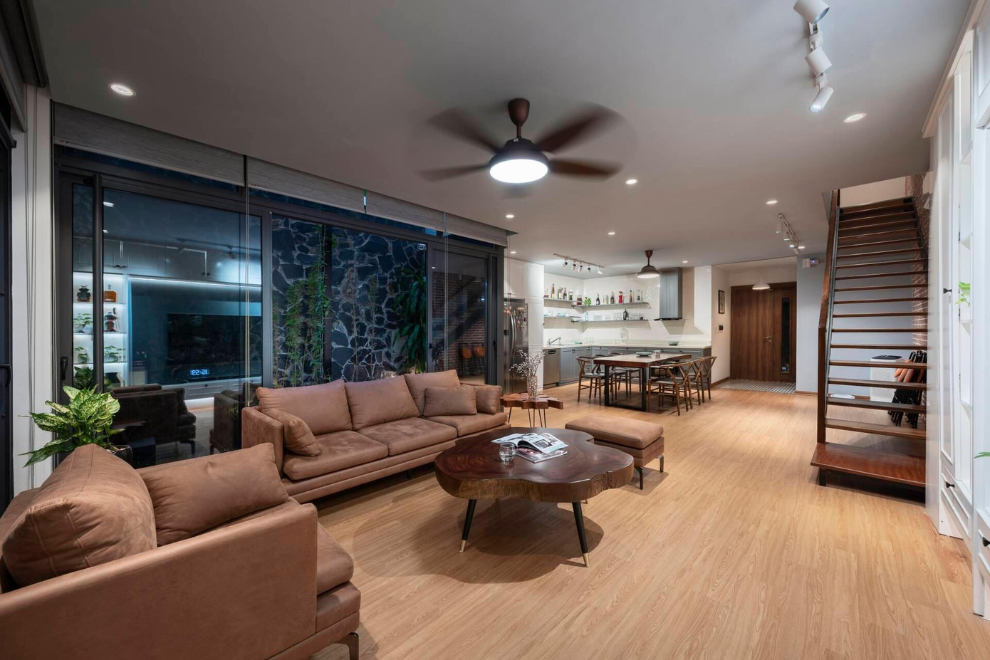 Tầng 1 là không gian sinh hoạt chung của gia đình bao gồm phòng khách được bố trí ghế sofa vải nhung màu nâu, kết hợp cùng bàn trà bằng gỗ.