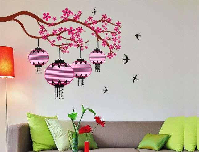 Để mang không khí Tết về nhà, gia chủ có thể trang trí tường phòng khách, phòng ngủ, bếp,… bằng decal dán tường hoặc giấy dán tường bằng cách lựa chọn những hình ảnh về hoa đào, hoa mai, bánh chưng, mâm ngũ quả,… mang màu sắc rực rỡ như đỏ, xanh, vàng,… Với cách này gia chủ vừa tiết kiệm được chi phí mà lại không tốn công sức. Tuy nhiên cần căn chỉnh kích thước của khu vực định dán decal để tấm decal không bị thừa hoặc thiếu.