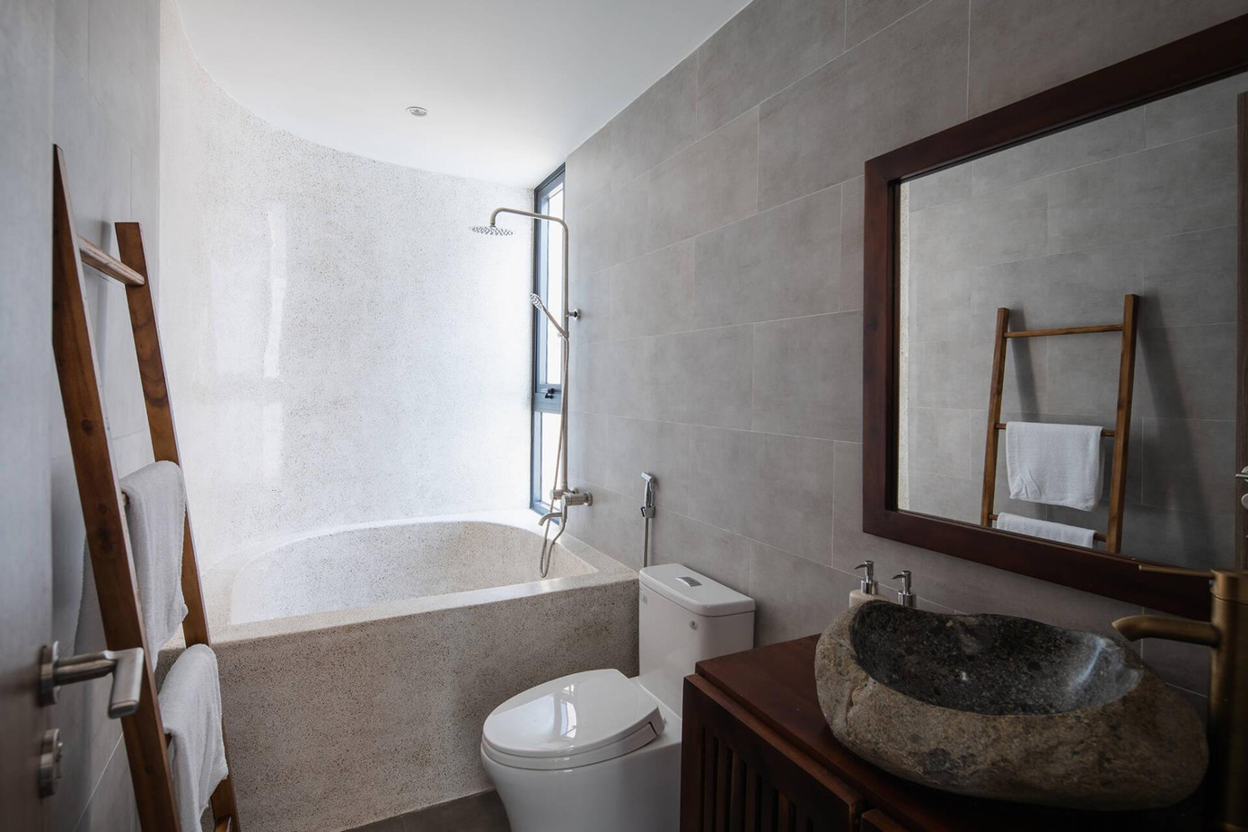 Cây xanh được bố trí ở góc ban công vừa đem lại sinh khí cho không gian vừa có chức năng như một “hàng rào xanh” cho bồn tắm. Trong phòng tắm sử dụng chất liệu mộc mạc như gỗ, đá tự nhiên làm điểm nhấn.