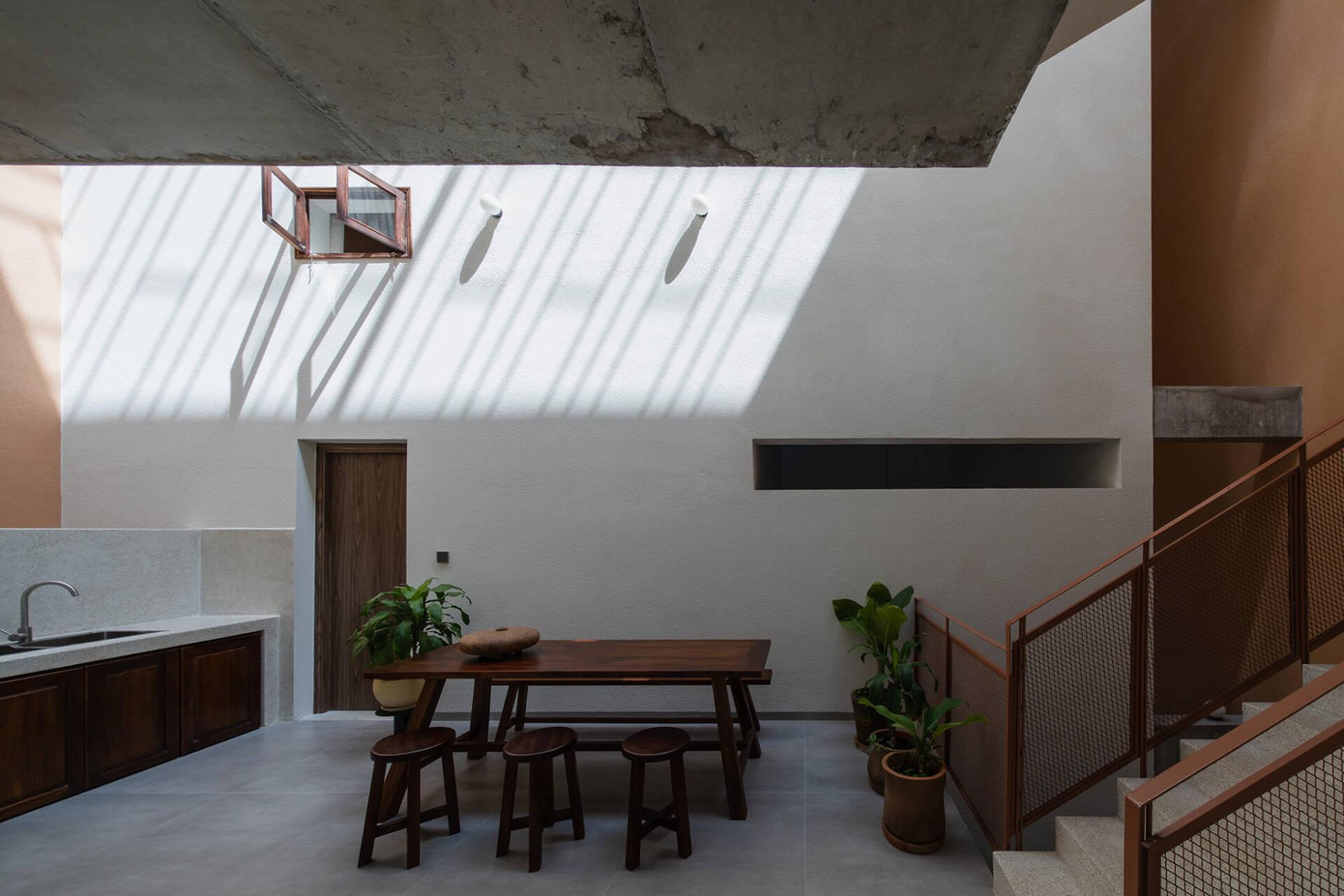 Khu vực bếp cho khách ở tầng 2 vô cùng đơn giản, với chất liệu gỗ chủ đạo, nhấn nhá bằng những chậu cây xanh mát.