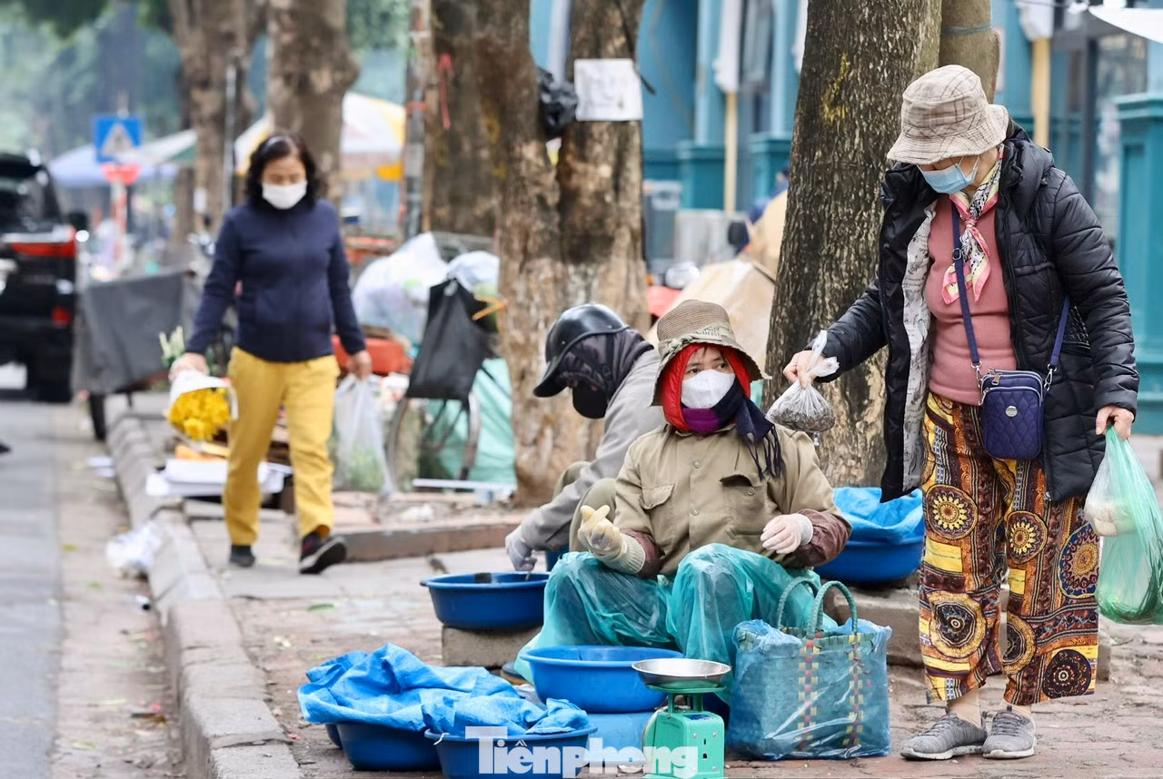 Trời mưa rét khiến công việc kinh doanh gặp khá nhiều khó khăn, lượng mua chậm, nhiều người ngả cả ô to để che chắn gió lùa ngồi ngóng khách.