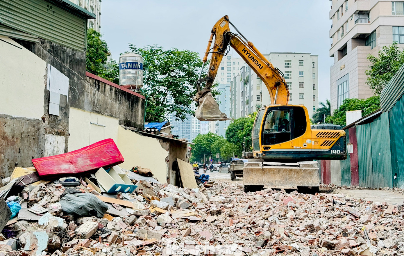 Ghi nhận sáng 4/6 tại ngõ 381 Nguyễn Khang, nhiều phương tiện gồm máy xúc, máy ủi, xe tải cùng hàng chục công nhân đang tiến hành cào xới, san lấp mặt bằng.