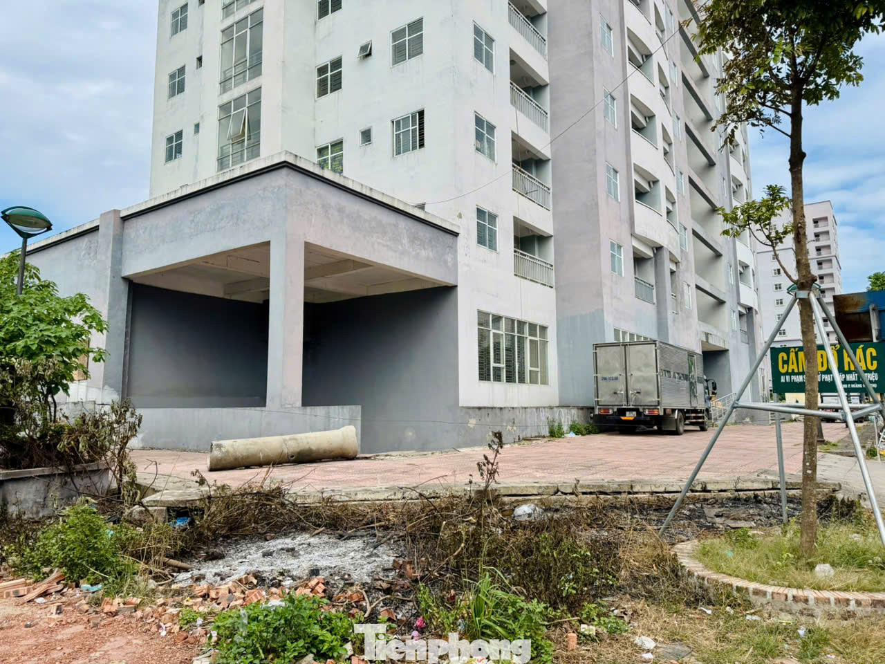 Lối vào sảnh tòa nhà xuống cấp, nhếch nhác, cỏ dại mọc, nhiều điểm tường bong tróc, cửa kính xập xệ, nhiều chỗ còn bị vỡ.