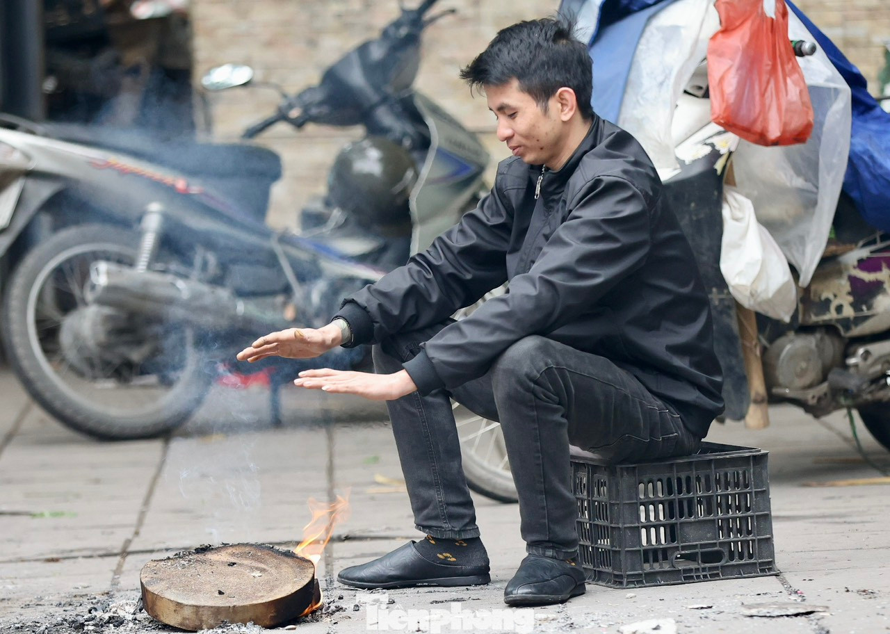 Nhiều người dân phải tranh thủ đốt củi ngay trên vỉa hè để sưởi ấm xua tan cái lạnh buốt.