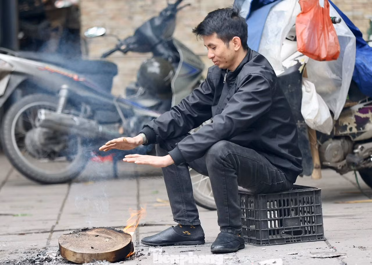 Nhiều người dân phải tranh thủ đốt củi ngay trên vỉa hè để sưởi ấm xua tan cái lạnh buốt.