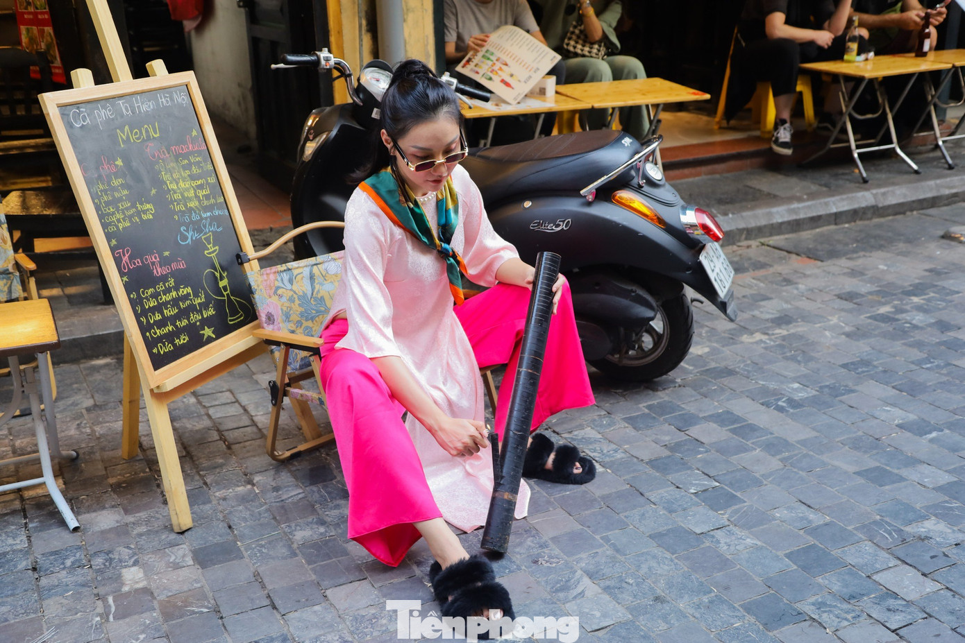 &quot;Khác với những năm trước, năm nay chúng mình lựa chọn chụp ảnh theo phong cách nghịch ngợm, nhí nhảnh một chút cho đúng với lứa tuổi cùng các đạo cụ như kính râm, khăn mỏ quạ... nhưng vẫn lưu giữ được nét đẹp truyền thống của áo dài&quot;, nhóm bạn trẻ đến từ quận Hai Bà Trưng chia sẻ.