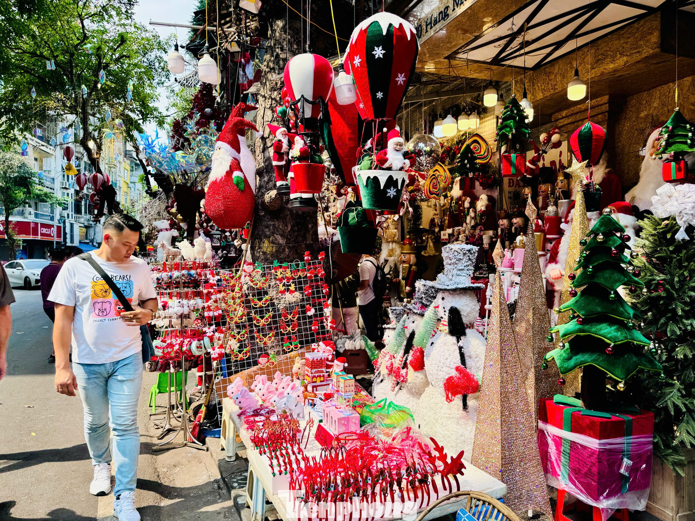 Tranh thủ thời tiết nắng đẹp, nhiều &quot;nàng thơ&quot; thích thú tạo dáng bên những gian hàng bán đồ Giáng sinh lung linh.