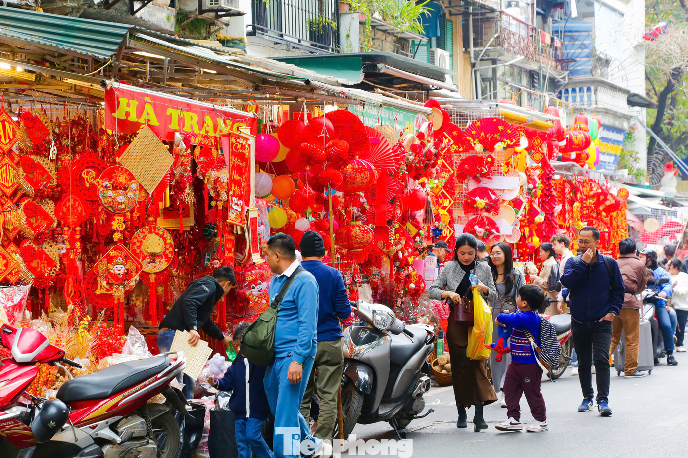 Các cửa hàng bày bán đa dạng đồ trang trí Tết như cành đào, pháo dây, bao lì xì, đèn lồng, câu đối... Các cửa hàng bày bán đa dạng đồ trang trí Tết như cành đào, pháo dây, bao lì xì, đèn lồng, câu đối...