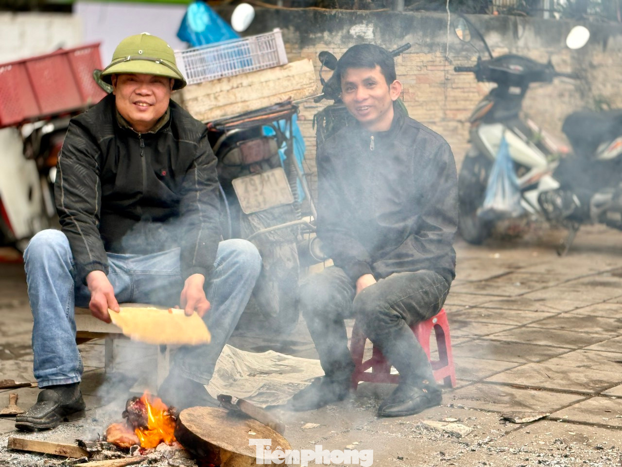 Nhiều người dân phải tranh thủ đốt củi ngay trên vỉa hè để sưởi ấm xua tan cái lạnh buốt.