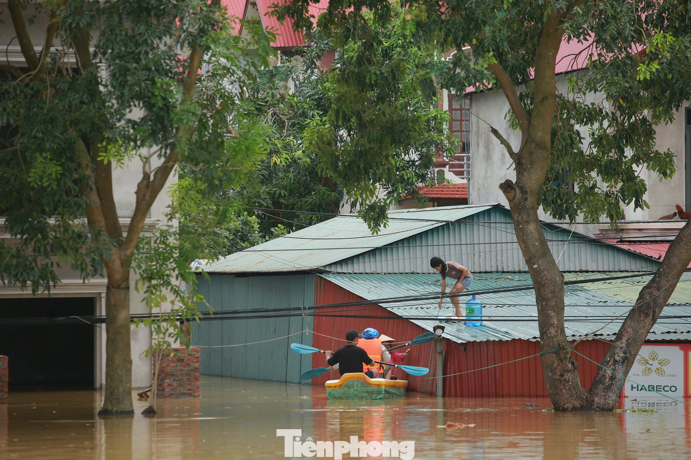Người dân xóm Mom phải trèo lên mái nhà để nhận đồ tiếp tế. Những hộ bị cô lập đang sống trong cảnh không điện, không nước sạch.
