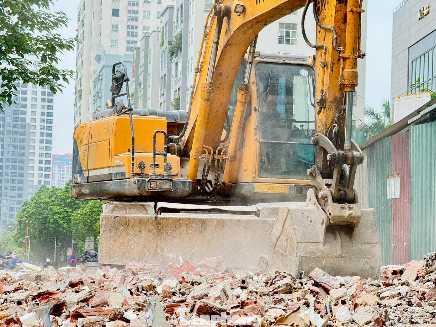 Ghi nhận sáng 4/6 tại ngõ 381 Nguyễn Khang, nhiều phương tiện gồm máy xúc, máy ủi, xe tải cùng hàng chục công nhân đang tiến hành cào xới, san lấp mặt bằng.