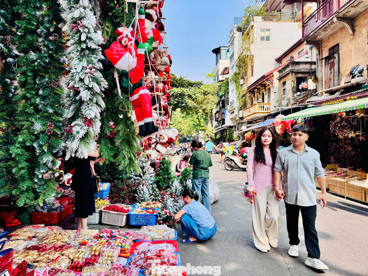 Tranh thủ thời tiết nắng đẹp, nhiều &quot;nàng thơ&quot; thích thú tạo dáng bên những gian hàng bán đồ Giáng sinh lung linh.