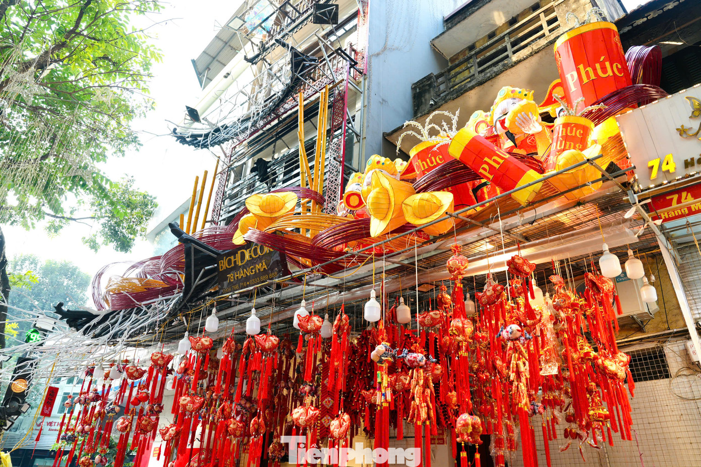 Các cửa hàng bày bán đa dạng đồ trang trí Tết như cành đào, pháo dây, bao lì xì, đèn lồng, câu đối... Các cửa hàng bày bán đa dạng đồ trang trí Tết như cành đào, pháo dây, bao lì xì, đèn lồng, câu đối...