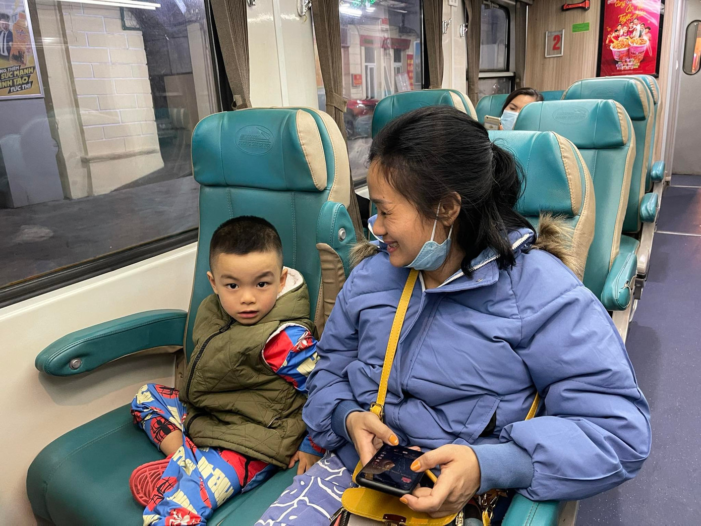 Chị Lệ cùng con trai đi trên chuyến tàu SE1 khởi hành lúc 22h20 cho biết: “Đây là năm thứ 3 xa nhà, mới có dịp về Vinh ăn Tết. Do tính chất công việc kết thúc muộn, đã hết xe khách nên gia đình lựa chọn đi tàu hoả, lần đầu có dịp đón Giao thừa trên tàu hoả nên cũng khá hồi hộp”. Ảnh: Trọng Tài