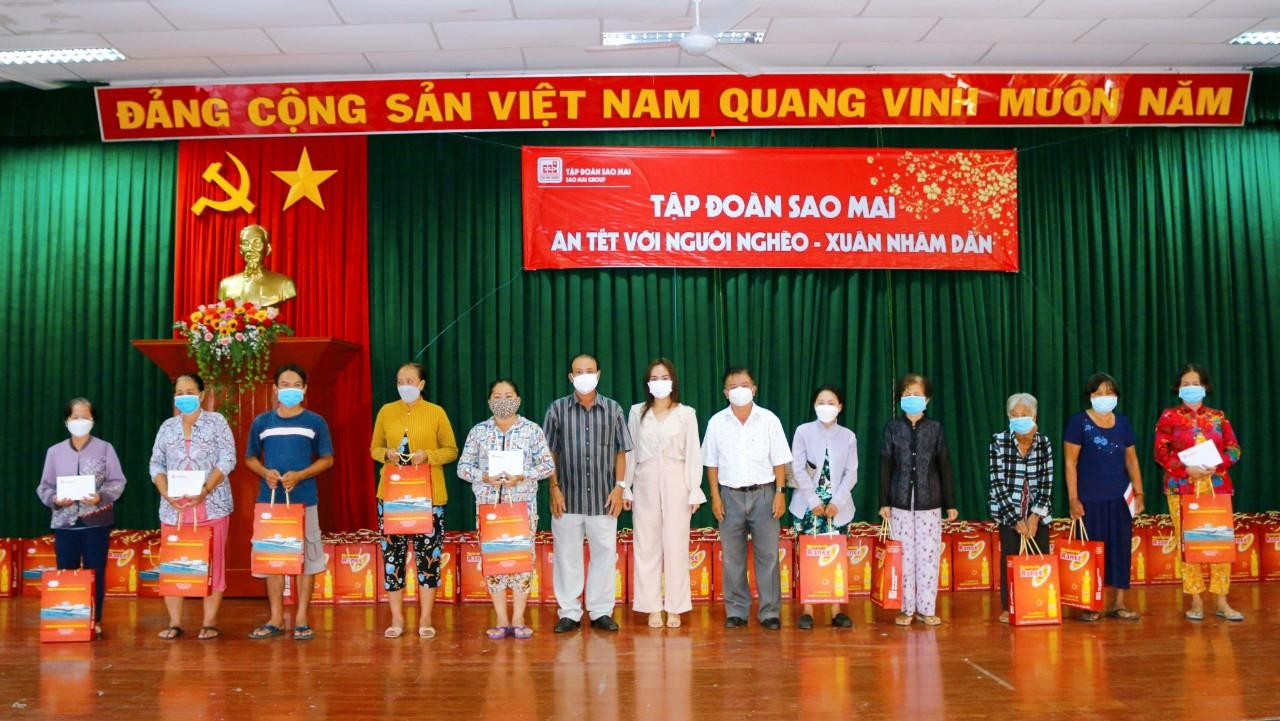 Bà Lê Thị Nguyệt Thu - Chủ tịch Tập đoàn Sao Mai ( thứ 7 bên phải qua) tặng quà cho bà con nghèo TP. Long Xuyên
