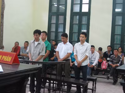 Bị cáo Thi (đứng đầu trước vành móng ngựa) cùng các bị cáo trong vụ án. Ảnh: BH