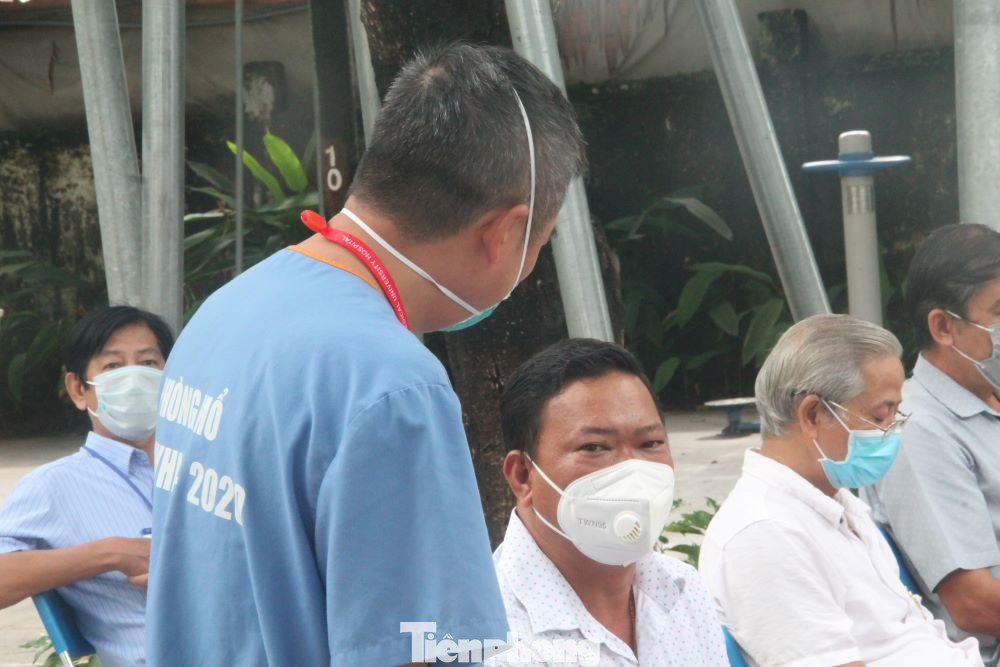 PGS.TS.BS Nguyễn Lân Hiếu (đứng) hỏi thăm tình hình tiêm vắc xin của người dân ở Bình Dương